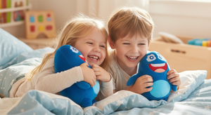 Zwei Kinder spielen lachend mit dem Cubanty Kuscheltier auf dem Bett – Freude, Nähe und Geborgenheit beim Spielen und Kuscheln